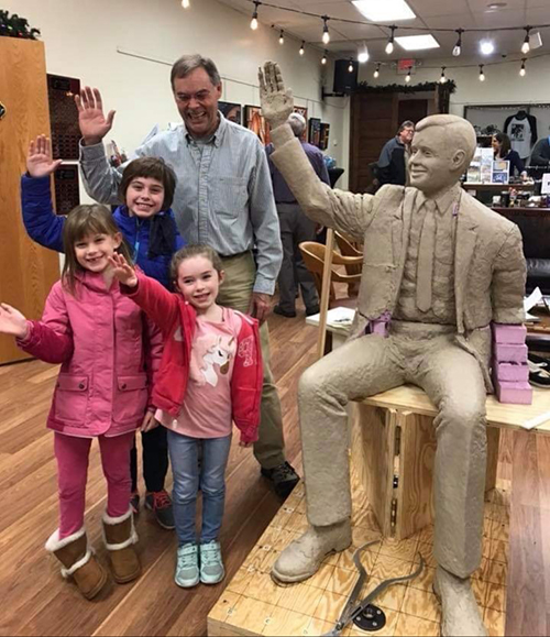 Mike with children waving beside Neil Armstrone clay model